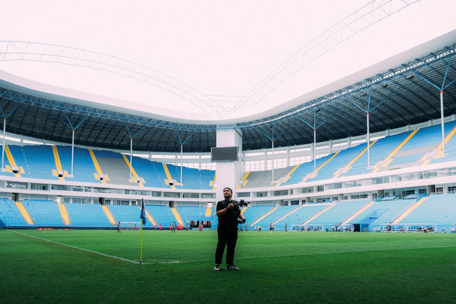 Photographer captures dynamic moment in a colorful football stadium.